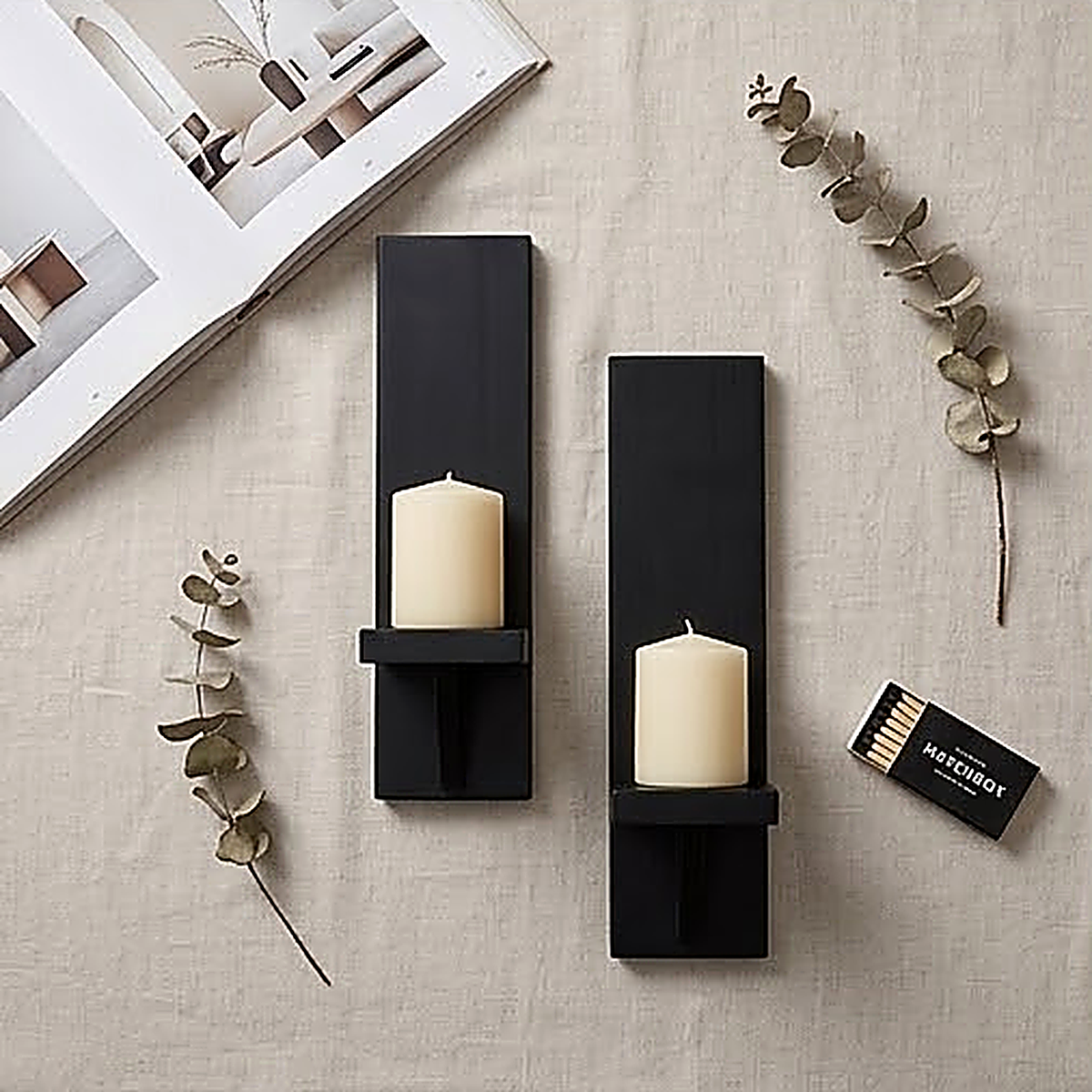 The black finish pair laid flat on linen with pillar candles, eucalyptus and a matchbox, showing the full 15.3 inch length