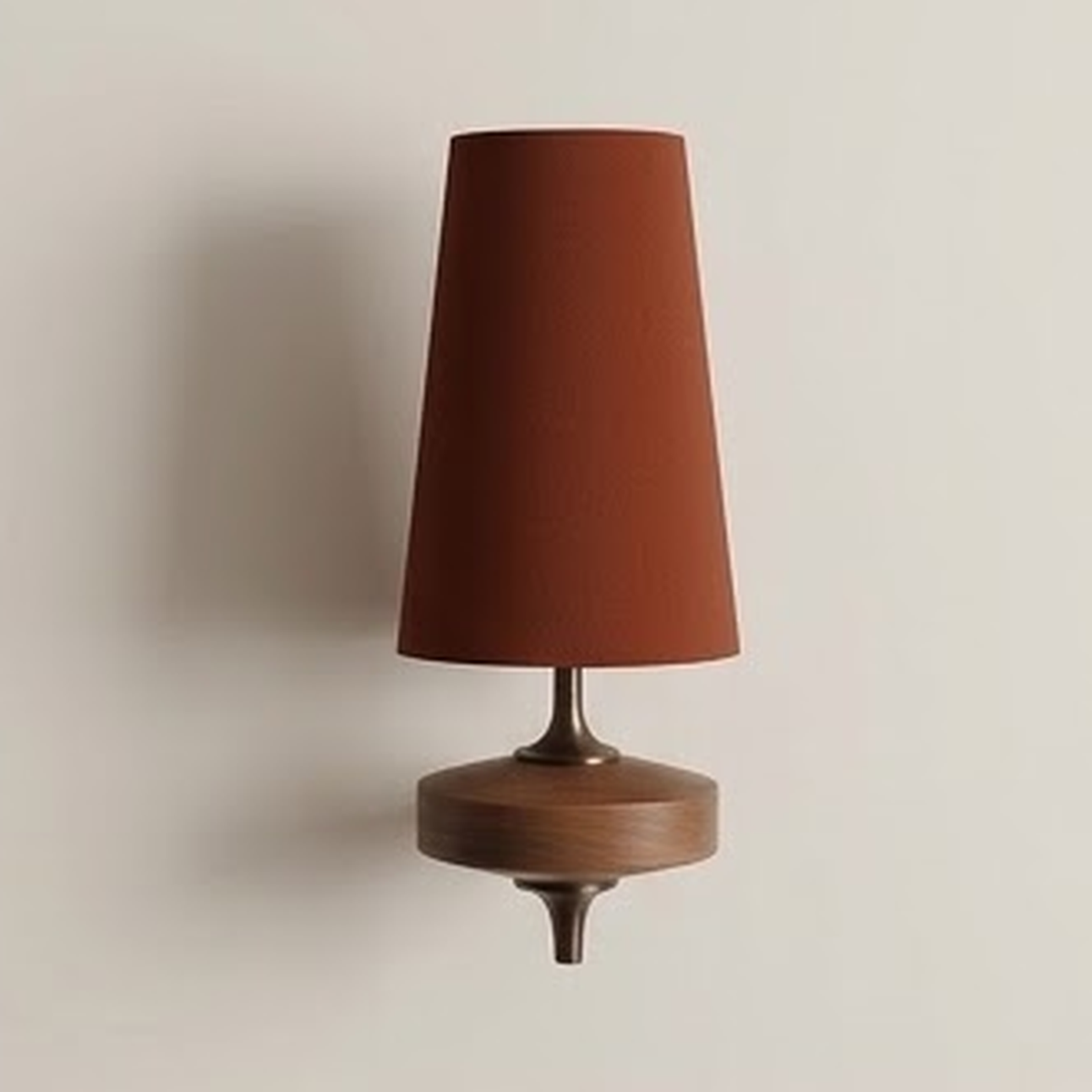 Rust fabric cone sconce lit on a warm neutral wall