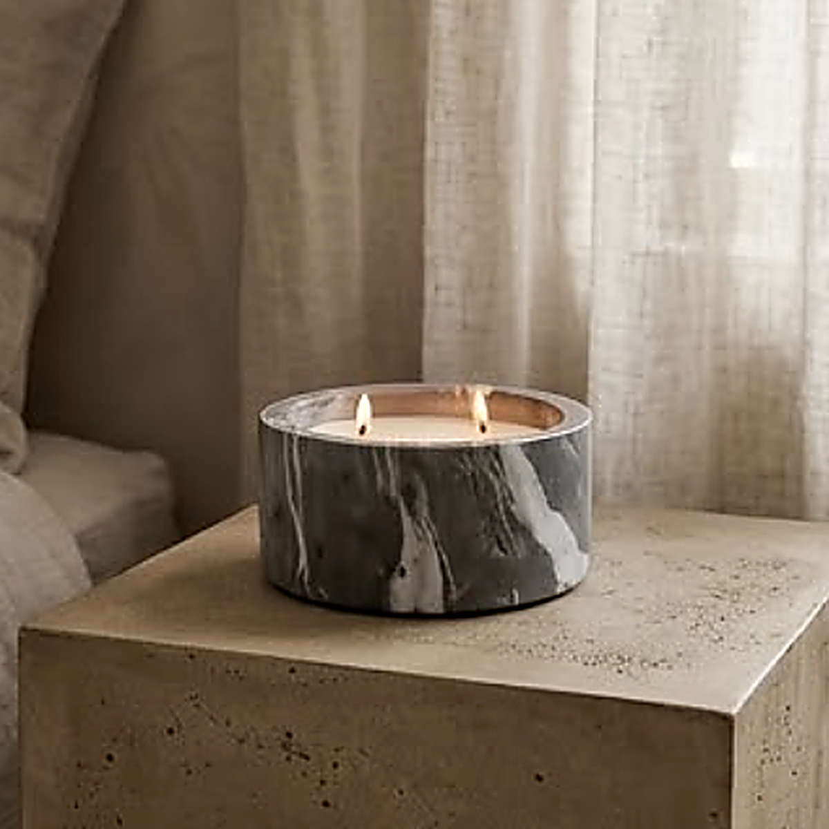 The grey marble vessel on a concrete plinth beside linen curtains. Wax and wicks are not included
