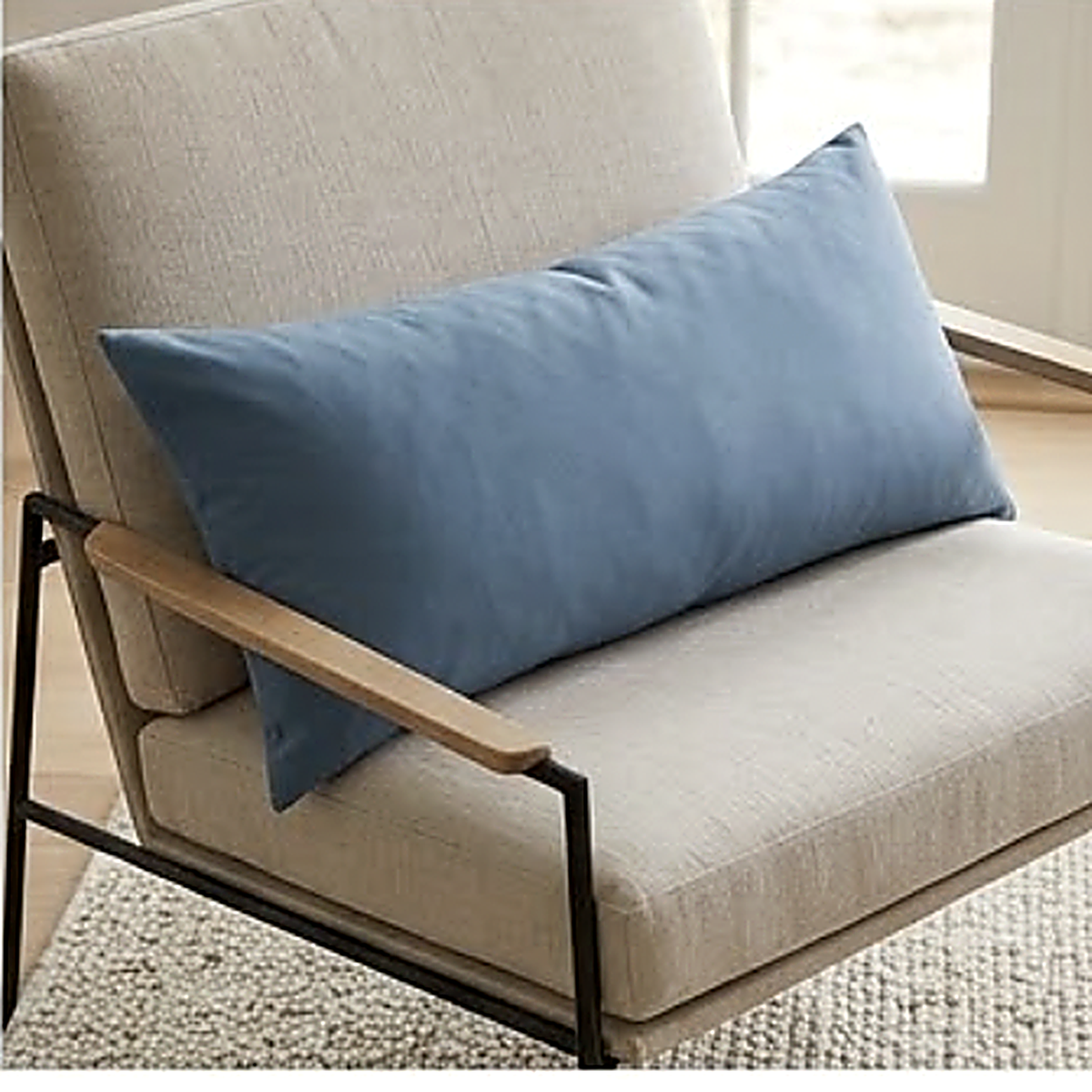 The Solid pattern as a 30 x 50 cm lumbar cushion on a low armchair with a black metal frame. Cover only