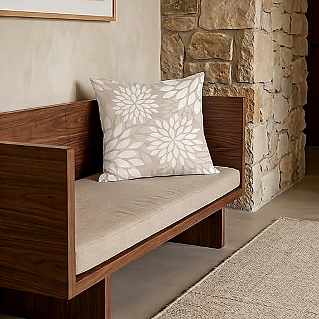 The Bloom pattern, a layered chrysanthemum head in taupe on warm white, on a walnut bench. Cover only, no cushion pad included