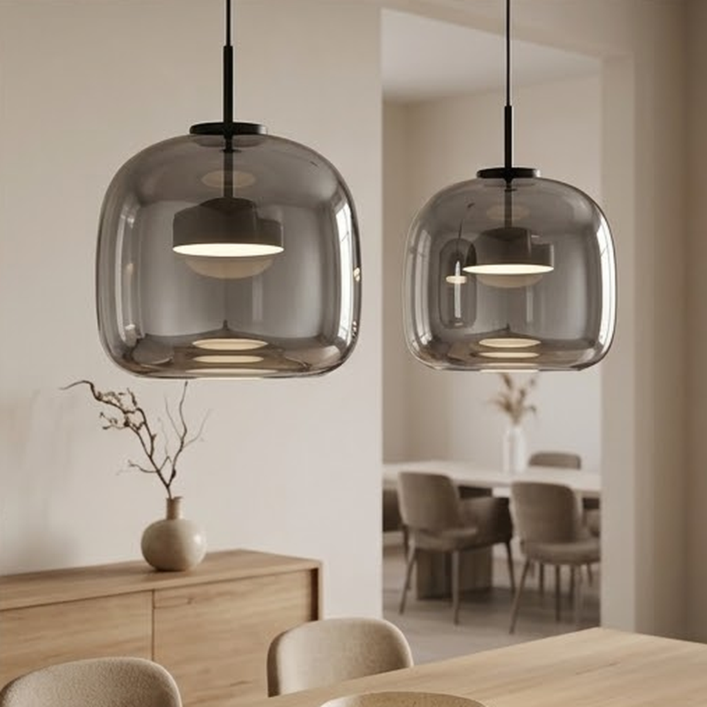 Close view of two lit smoky gray glass pendants showing the inner glowing disc