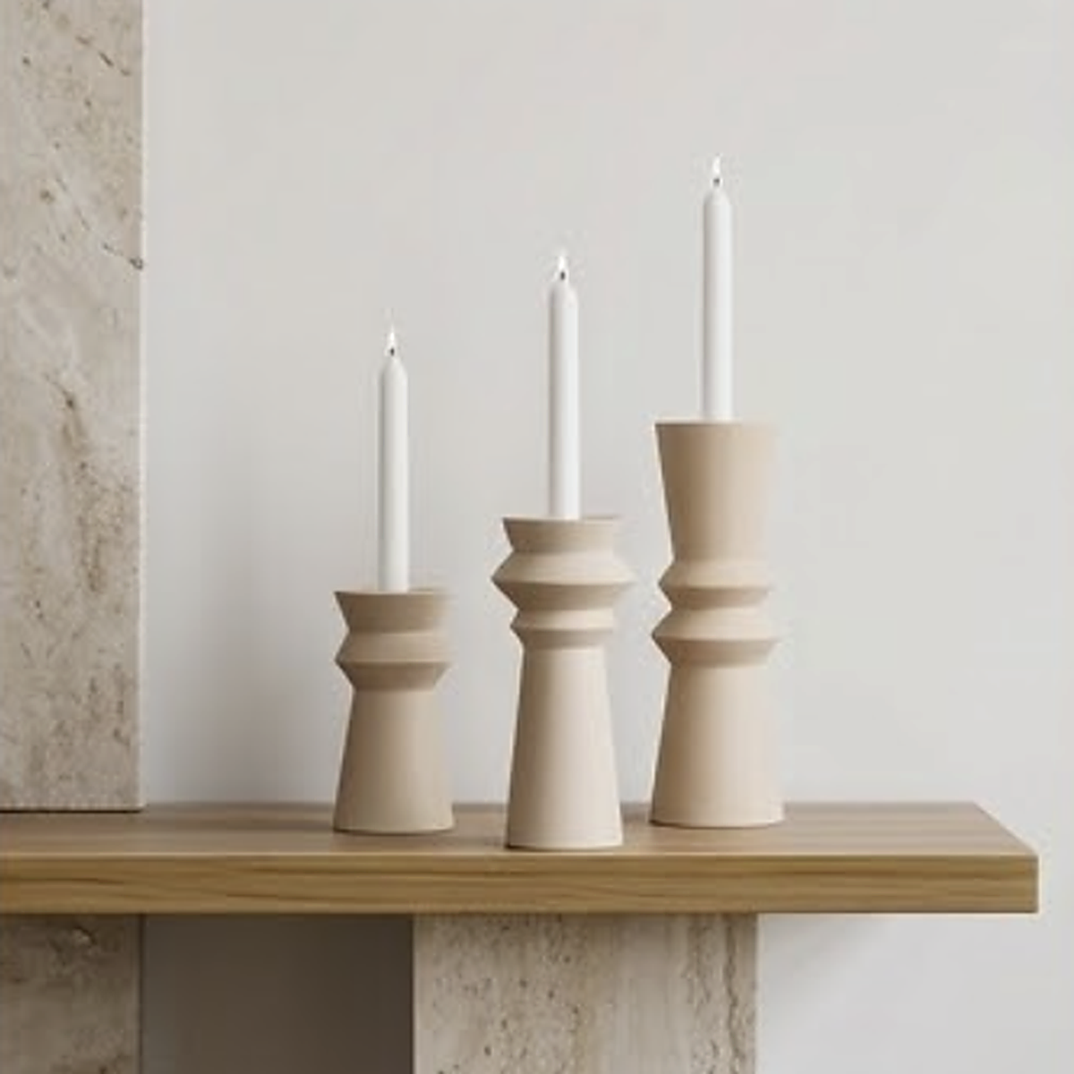 All three sizes together and lit on an oak shelf. Small 15.5 cm, medium 18.5 cm, large 22 cm, left to right